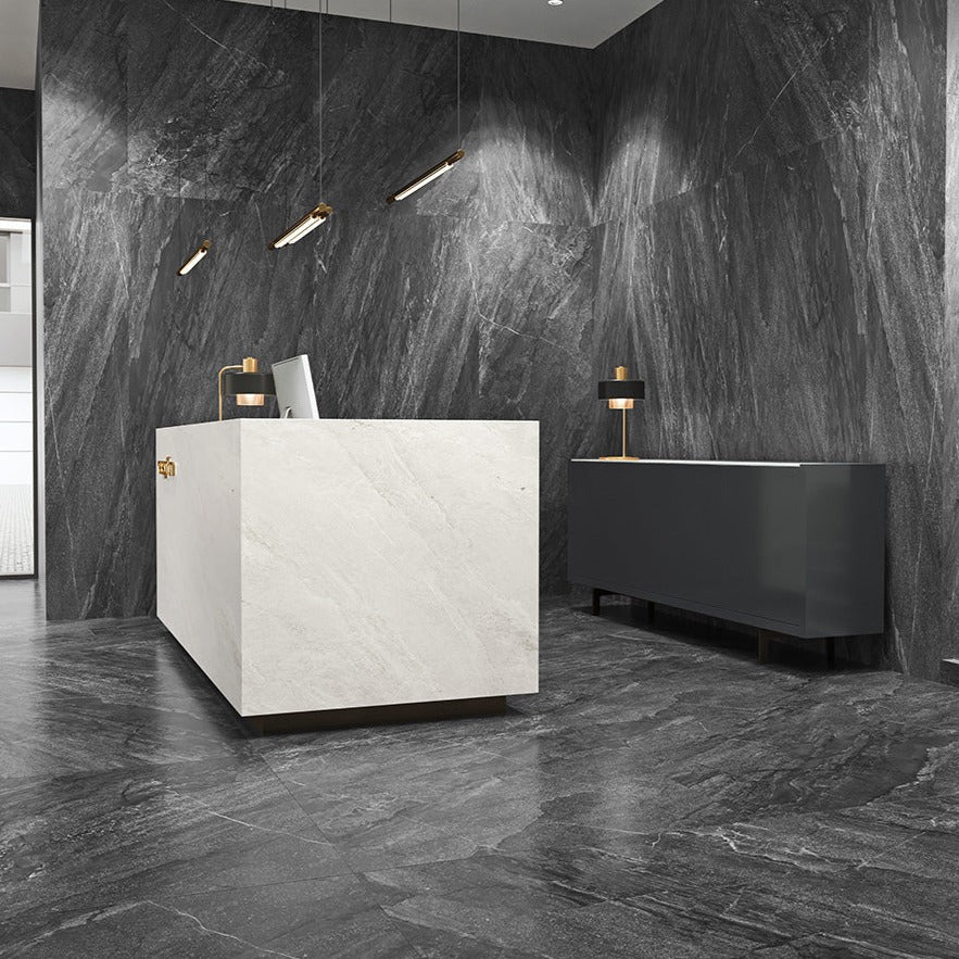 Agathos Anthracite matte porcelain tile with a stone design, for floors and walls. Made in Italy, installed in a room.