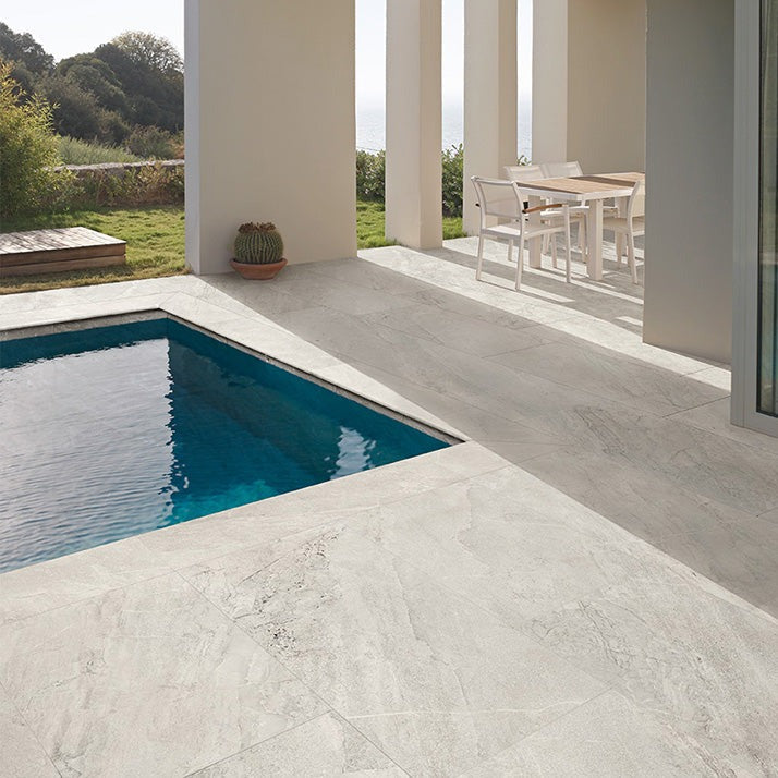 Agathos White matte porcelain tile with a stone design, for floors and walls. Made in Italy, installed in a room.