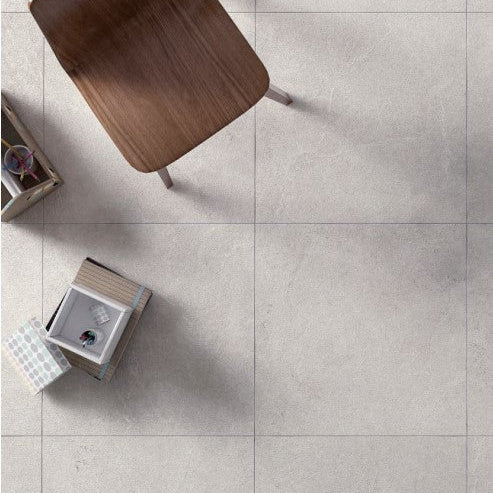 Lithos Stone Cream matte porcelain tile with an off-white stone design, for floors and walls. Installed in a room.