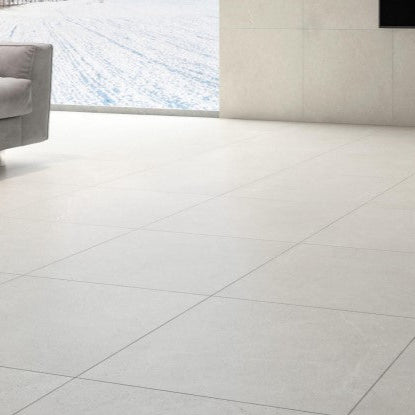 Lithos Stone Cream matte porcelain tile with an off-white stone design, for floors and walls. Installed in a room.