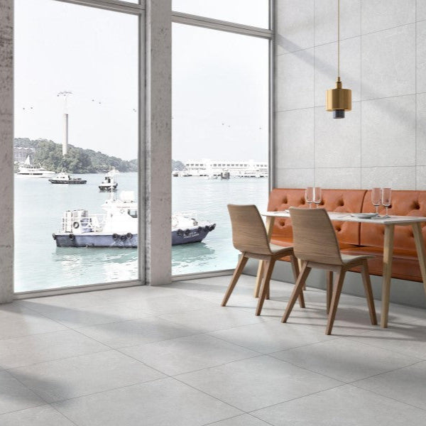 Lithos Stone Pearl matte porcelain tile with a grey stone design, for floors and walls. Installed in a room.