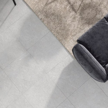 Lithos Stone Pearl matte porcelain tile with a grey stone design, for floors and walls. Installed in a room.